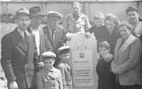  ?? [COURTESY OF RUTH BRANDSPIEG­EL VIA AP] ?? In this June 1948 photo provided by Ruth Brandspieg­el, the Eisenberg and Brandspieg­el families gather around the tombstone of Abraham Eisenberg at the Hallein Displaced Persons Camp in Austria.