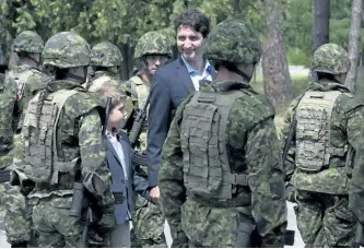  ?? THE CANADIAN PRESS FILES ?? Canadian Prime Minister Justin Trudeau and his son Xavier review an honour guard as they arrive at the Internatio­nal Peacekeepi­ng and Security Centre in Yavoriv, Ukraine in 2016. Trudeau has finally unveiled Canada’s long-awaited commitment to UN...