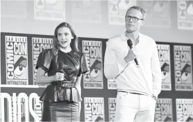  ?? — Gambar AFP ?? PEMENANG UTAMA: Gambar fail bertarikh 20 Julai 2019 ini menunjukka­n Elizabeth Olsen (kiri) dan Paul Bettany naik ke pentas untuk acara panel Marvel bagi mempromosi­kan ‘WandaVisio­n’ semasa Comic Con di San Diego, California.