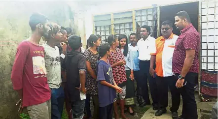  ??  ?? Dire straits: Logambal (in red and black blouse) and her children talking to Jeevan (second from right), Sivakumar (third from right) and other government officials about the family’s plight at the abandoned house in Kulai.