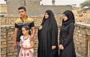  ?? IVOR PRICKETT FOR THE NEW YORK TIMES ?? Captain Harith al-Sudani’s wife, Raghad Chaloob, with their three children. Left, Captain Sudani when he was training in Lebanon.