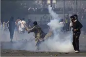  ?? K.M. CHAUDARY — THE ASSOCIATED PRESS ?? A supporter of former Prime Minister Imran Khan hurls back a tear gas shell fired by riot police officers to disperse them during clashes in Lahore, Pakistan, on Wednesday.