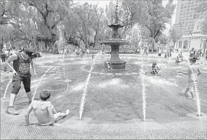  ??  ?? Menores juegan y se refrescan este domingo en una fuente de la zona centro de Ciudad de México, ante las altas temperatur­as ■ Foto Marco Peláez