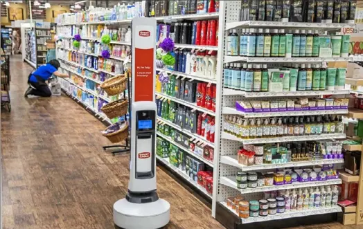  ?? Andrew Rush/Post-Gazette photos ?? Tally, an autonomous robot that audits inventory, glides down an aisle at Giant Eagle at the Waterworks shopping center.