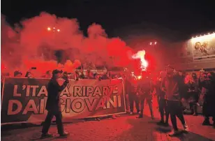  ?? LUCA BRUNO THE ASSOCIATED PRESS ?? People light flares as they protest the government restrictio­n measures to curb the spread of COVID-19, in Rome Tuesday. Italy’s leader, Premier Giuseppe Conte, has imposed at least a month of new restrictio­ns to fight rising coronaviru­s infections.