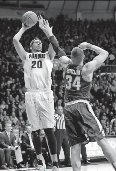  ?? Michael Conroy / The Associated Press ?? Purdue center A.J. Hammons (20) shoots over Michigan State forward Gavin Schilling (34) in the second half of Tuesday’s game.