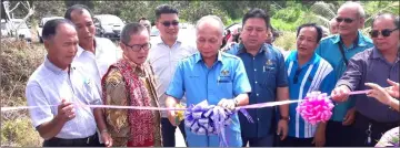  ??  ?? Masir (centre) cuts the ribbon while Nili (second left) and other community leaders look on.