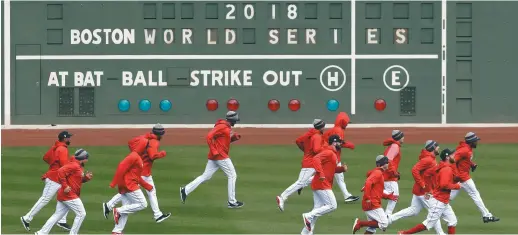  ?? - Associated Press: Elise Amendola ?? Les joueurs des Red Sox de Boston se sont entraînés dimanche devant le fameux tableau indicateur du Monstre vert du Fenway Park.