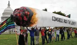  ?? Olivier Douliery / Tribune News Service ?? Activists from D.C. Marijuana Justice hold a giant representa­tion of a marijuana cigarette in support of cannabis reform legislatio­n.