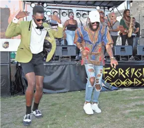  ?? PAT A. ROBINSON / MILWAUKEE JOURNAL SENTINEL ?? Christophe­r Gilbert and Klassik dance to the music of Foreign Goods at the Rock the Green Festival. More photos at jsonline.com/music.