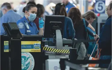  ?? JAY JANNER/USA TODAY NETWORK ?? A TSA screening officer wears a face mask at Austin-Bergstrom Internatio­nal Airport in Austin, Texas, on March 5 as a precaution against the coronaviru­s pandemic.