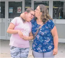  ?? RYAN TAPLIN • THE CHRONICLE HERALD ?? Amanda Lawlor gives her daughter Mairin, 12, a kiss as they are interviewe­d outside Caledonia Junior High on Monday, July 19, 2021. Mairin is starting at Caledonia this September and her mom is concerned the lack of accessibil­ity at the school.