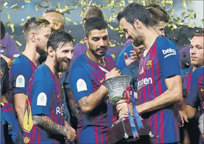  ?? FOTO: AP ?? Leo Messi, Luis Suárez y Sergio Busquets sonríen tras recibir el trofeo de la Supercopa de España