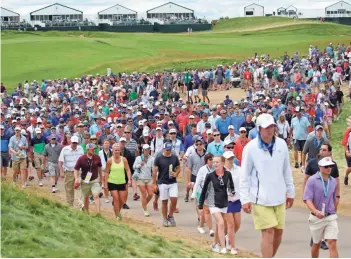  ?? MIKE DE SISTI / MILWAUKEE JOURNAL SENTINEL ?? Spectators make their way near the 10th hole during the U.S. Open on Sunday at Erin Hills. “From a spectator standpoint, it was a very good experience,” USGA Executive Director Mike Davis said of the course.