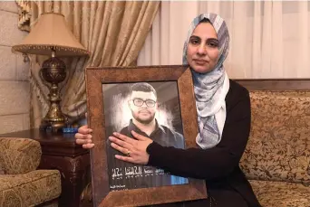  ?? (Heidi Levine/for The Washington Post) ?? Mona Abdel Jabbar sits with a photograph of her late son, 17-year-old Tawfic Abdel Jabbar, at her home in the West Bank on Wednesday.