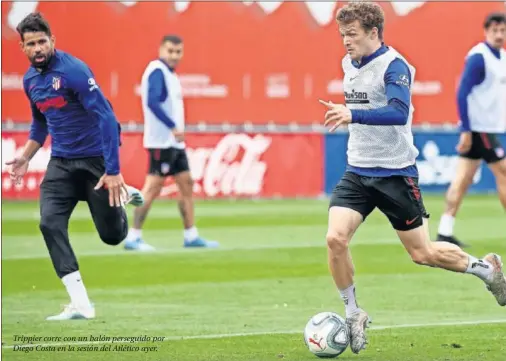  ??  ?? Trippier corre con un balón perseguido por Diego Costa en la sesión del Atlético ayer.