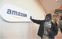  ?? AP ?? Zavian Tate pushes a large Amazon Dash button in Birmingham, Ala. The buttons are part of the city’s pitch for Amazon offices.