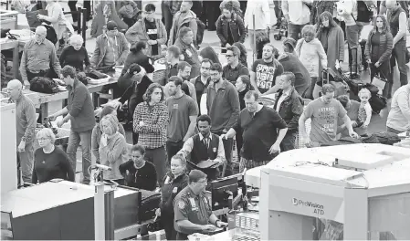  ?? AP ?? Travelers wait in long lines to pass through a security checkpoint at Denver Internatio­nal Airport on Nov. 21.