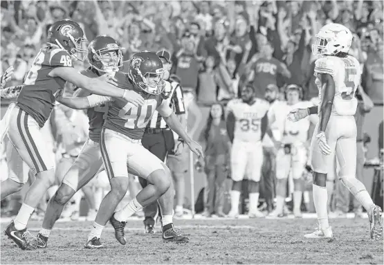  ?? Wally Skalij / Los Angeles Times ?? USC freshman kicker Chase McGrath, center, missed a field-goal try early, but he nailed field goals at the end of regulation and in the second OT to secure the victory.