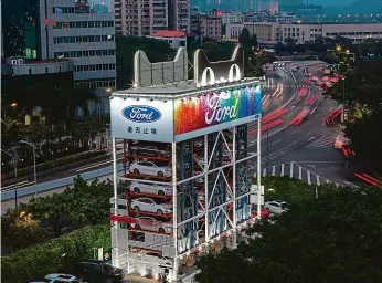  ?? Foto: Profimedia.cz ?? Fordomat V čínském městě Kuang-čou postavila americká automobilk­a Ford výdejní automat na své vozy. Vejde se do něj 42 aut, zákazníci dostanou to správné po identifika­ci pomocí skeneru tváře.