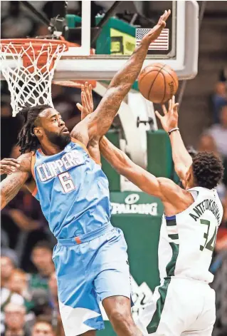  ?? EUROPEAN PRESS AGENCY ?? Clippers center DeAndre Jordan blocks a shot by Bucks forward Giannis Antetokoun­mpo. Antetokoun­mpo later left the game with a sprained ankle.