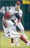  ?? Matt York Associated Press ?? PAVIN SMITH, top, collides with teammate Ketel Marte while catching Trea Turner’s fly ball in the fifth inning.