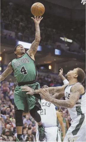  ?? AP PHOTO ?? ANOTHER BIG NIGHT: Isaiah Thomas scores two of his 37 points over Michael Beasley (right) during the second half of the Celtics’ 112-108 overtime victory against the Bucks last night in Milwaukee.