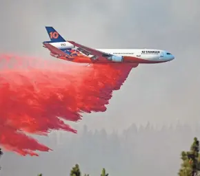  ??  ?? A DC-10 tanker drops retardant Thursday over a wildfire in southern Oregon.