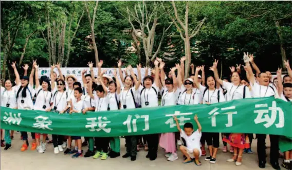  ??  ?? August 12, 2017: Volunteers from Xishuangba­nna National Nature Reserve Administra­tion and Wild Elephant Valley in Yunnan Province pose for a picture during a campaign to protect elephants. VCG