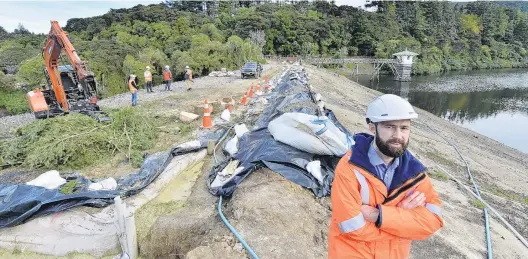  ?? PHOTO: GERARD O’BRIEN ?? Massive job . . . Dunedin City Council planning and delivery manager Jared Oliver stands on the new crest of the Ross Creek Reservoir dam.