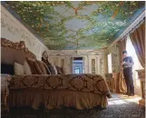  ??  ?? Reynaldo Ramirez, Victor Hotels director of sales, stands in the Venus Suite at The Villa Casa Casuarina in Miami Beach, Fla. The suite is one of 10 suites featuring frescos and other opulent artwork created by fashion designer Gianni Versace, who once...