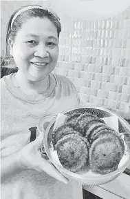  ??  ?? SEDAP: Ibu Bernadatte, Demit Lamit yang berasal dari Pelugau, Balingian menunjukka­n hasil kuih tradisiona­l, penyaram yang dimasak bersama anaknya.