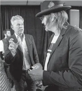  ??  ?? David Foster, left, chats with Victoria-based folk musician Daniel Lapp at a celebratio­n of the B.C. portion of the Great Trail at the Inn at Laurel Point on Thursday.