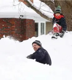  ?? TONY CALDWELL ?? A father and son clear their driveway after the storm.