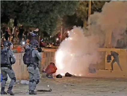  ?? (AFP) ?? Tear gas billows amid clashes between Israeli security forces and Palestinia­n protesters at the Al Aqsa Mosque compound, in Jerusalem on Friday