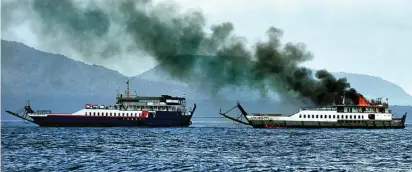  ?? RAMADA/JAWA POS RADAR BANYUWANGI ?? KEPULKAN ASAP HITAM: Api membakar bagian atas KMP Labrita Adinda di Selat Bali kemarin. Di sampingnya, KMP Karya Maritim 2 menarik KMP Labrita Adinda ke arah pantai Banyuwangi kemarin. Foto kiri, proses evakuasi penumpang. Seluruh penumpang dan kru...