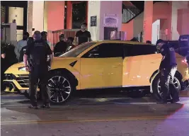  ?? CARL JUSTE cjuste@miamiheral­d.com ?? Miami Beach police search a Lamborghin­i as a curfew went into effect Thursday night.