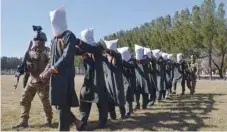  ?? — AFP ?? Afghan security forces escort suspected Taliban fighters as they are being presented in front of the media after an operation at the National Directorat­e of Security headquarte­rs in Herat on Tuesday.