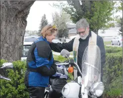  ?? NEWS PHOTO MO CRANKER ?? Reverend Blaine Schaufele performs a blessing with Sonya Teel (left) and Ryan Maxwell (below) Sunday morning during the annual Blessing of the Bikes ceremony. The event is held each year to kickoff the riding season and remember those who have fallen...