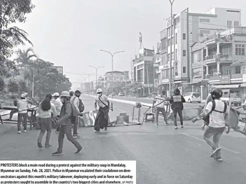  ?? AP Photo ?? Protesters block a main road during a protest against the military coup in Mandalay, Myanmar on sunday, Feb. 28, 2021. Police in Myanmar escalated their crackdown on demonstrat­ors against this month's military takeover, deploying early and in force on saturday as protesters sought to assemble in the country's two biggest cities and elsewhere.