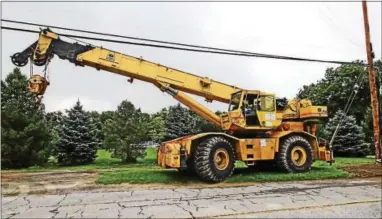  ?? CHRIS BARBER — DIGITAL FIRST MEDIA ?? One of the pieces of road equipment involved in the bridge collapse on Thursday stands rescued up the street.