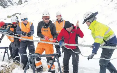  ?? PHOTO: MATTHEW MCKEW ?? Pulling together . . . NZSki staff pull the cable taut as specialist metal rope splicer Hannes Koller thrashes the pieces into place at The Remarkable­s skifield.