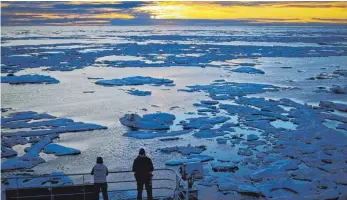 ?? FOTO: DPA ?? Wissenscha­ftler schauen in der Victoria Strait von dem finnischen Eisbrecher MSV Nordica herunter, der durch Treibeis im kanadisch- arktischen Archipel fährt.