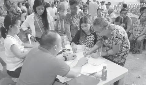  ?? JOY TORREJOS ?? An elderly woman looks for her name on the list during the distributi­on of financial assistance for senior citizens by the Department of Social Welfare and Developmen­t- 7 at the barangay gym in Looc, Mandaue City.