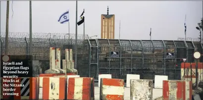  ?? PHOTO: GETTY IMAGES ?? Israeli and Egyptian flags beyond heavy security blocks at the Nitzana border crossing