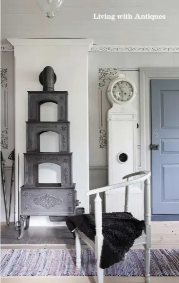  ??  ?? ABOVE A Norwegian cast-iron stove, shaped in steps, works in a similar way to a ceramic stove and is highly efficient at emitting heat. The Empire-style grandfathe­r clock and the chair are from the farm.