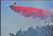  ?? AP/Daily Camera/PAUL AIKEN ?? An air tanker plane drops retardant on a wildfire west of Boulder, Colo., on Sunday.