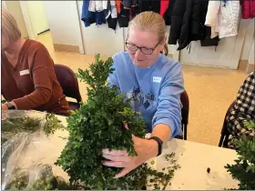  ?? MARTIN MCCONNELL -- THE MORNING JOURNAL ?? Claudia Szippl works on Dec. 13on her boxwood Christmas tree project as part of an Avon-on-the-Lake Garden Club holiday workshop.