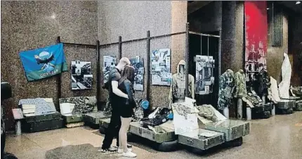  ?? MPL ?? Una pareja observa uniformes y objetos traídos del frente de Donbass en la muestra Este ucraniano