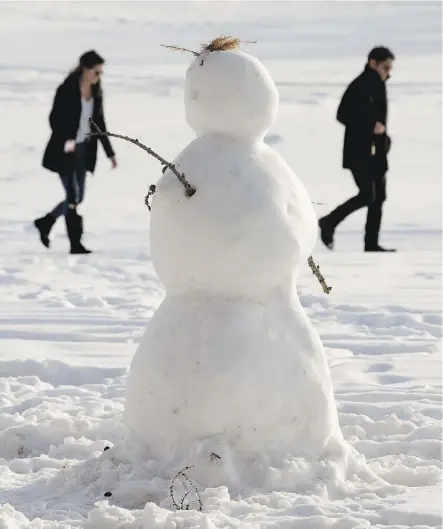  ?? DAVID BLOOM ?? A snowman watches over pedestrian­s in Hawrelak Park on Jan. 2.